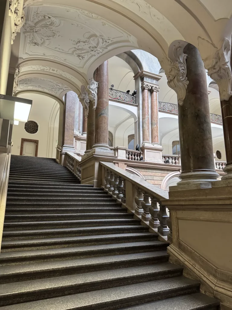 Justizpalast München: Treppe hinauf zwischen Säulen und Bögen