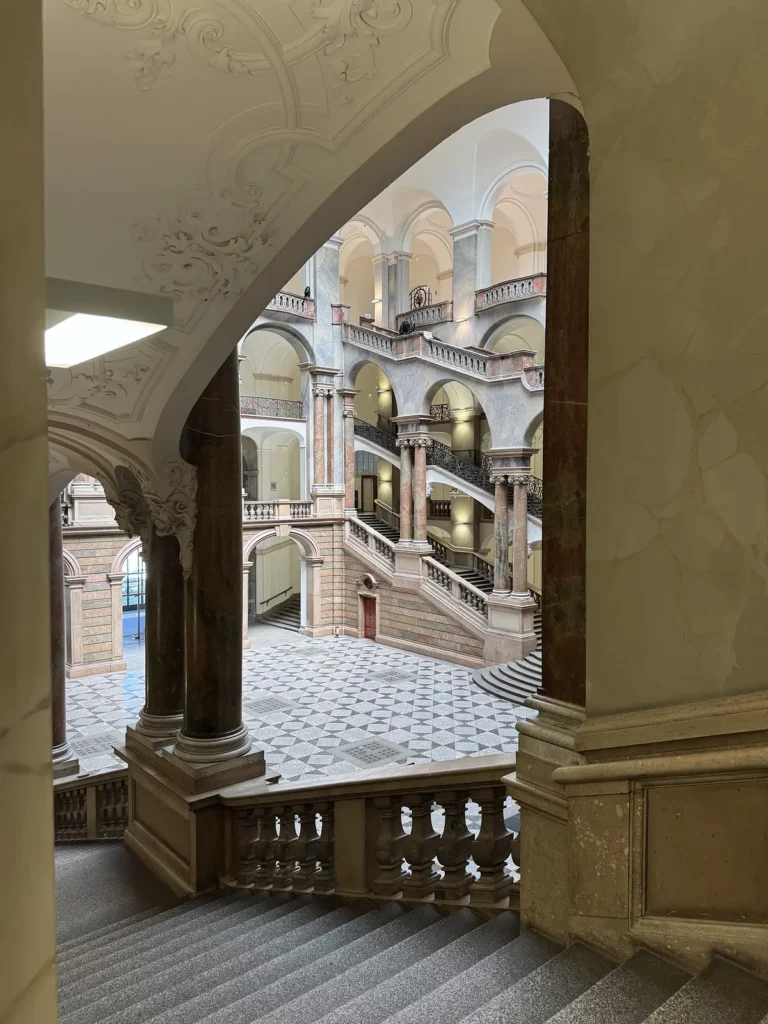 Justizpalast München: Blick durch einen Bogen in die Treppenhalle